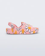 Side view of a pink Free Cute baby sandal with daisy print