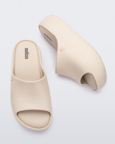 Top and side view of a pair of beige Free Platform women's slides
