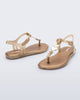 Angled view of a pair of gold glitter Solar kids sandal with a heart embellishment