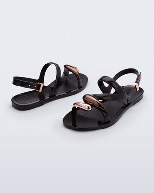 Back and angled view of a pair of black Iris sandals with copper upper embellishments