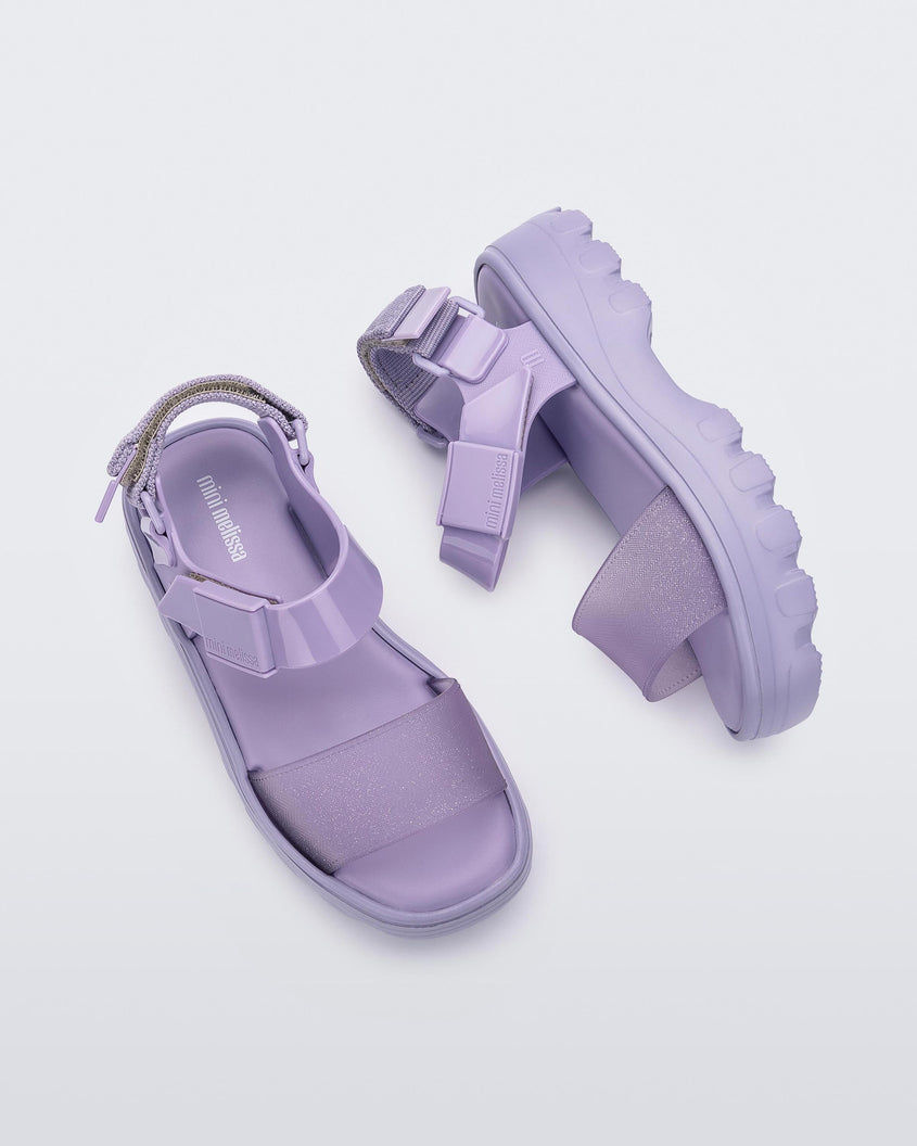 Top and side view of a pair of Mini Melissa Kick Off platform sandals in lilac with adjustable velcro ankle straps 