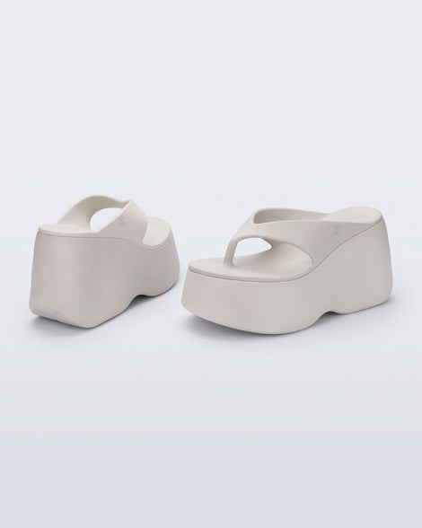 Back and angled view of a pair of beige Free Thong  Wedge Platform heels