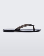 Side view of a clear black Harmonic Jelly flip flop