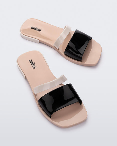 Angled view of a pair of black and beige Ivy women's slide