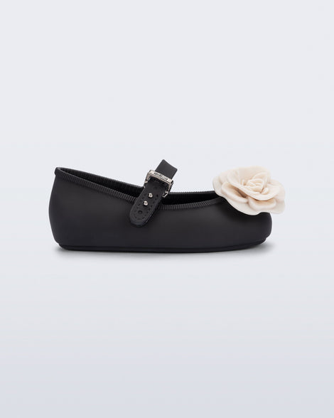 Side view of a black Soft Ballerina baby flat with beige flowers