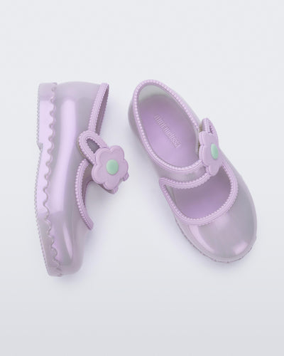 Side and top view of a pair of pearly lilac Hip Ballerina baby flats with strap with flower
