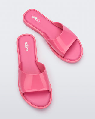 An angled top view of a pair of pink tortoiseshell Melissa Miranda slides
