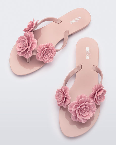 Top view of a pair of pink Harmonic Springtime women's flip flop with 3 pink flowers.