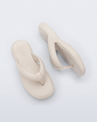 Side and top view of a pair of beige Free Low flip flops