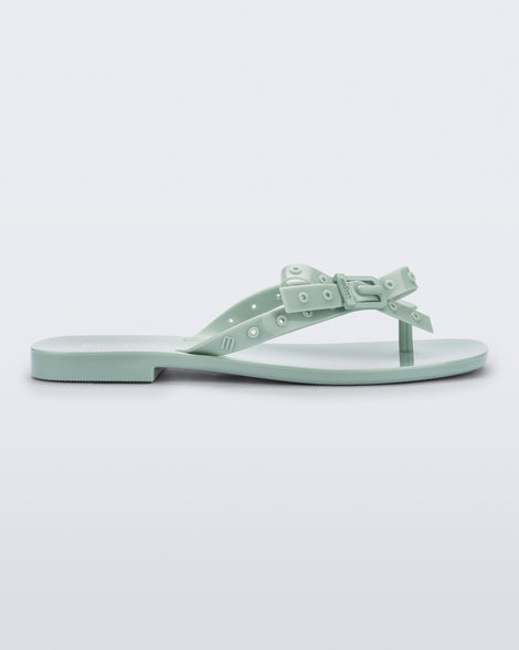 Side view of a green Harmonic Squared flip flop with bow on strap