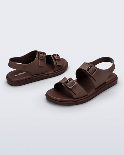 Side and angled view of a pair of brown Wave Sandals with two straps with buckles and a back strap