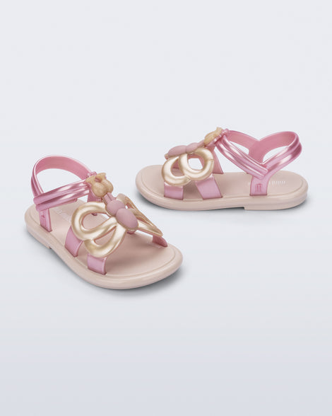 Side and angled view of a pair of pink strap, beige sole Hip Butterfly baby sandals
