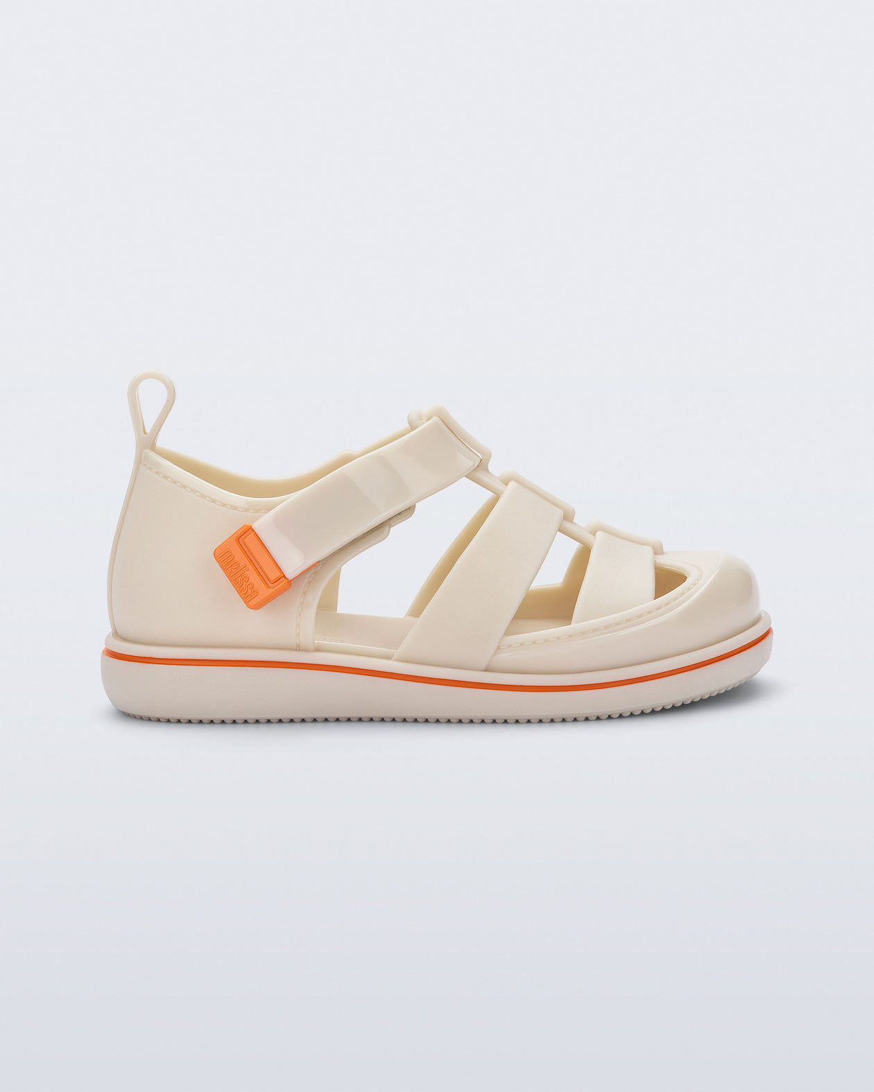 Side view of a beige Smash closed toe baby sandal with orange trim