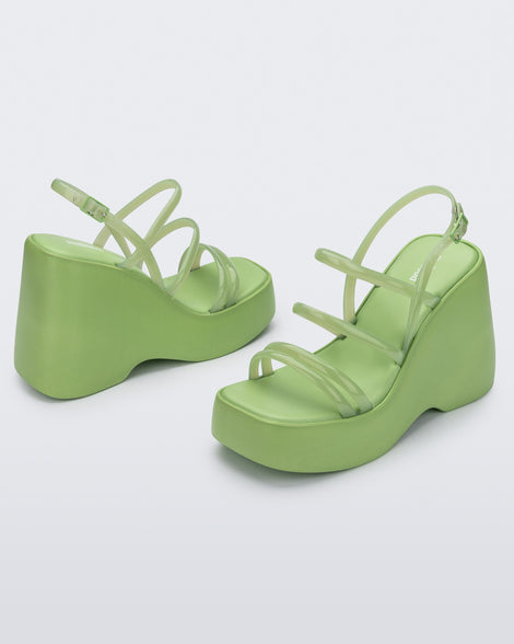Angled view of a pair of green Jessie platform wedge sandals with side buckle ankle strap