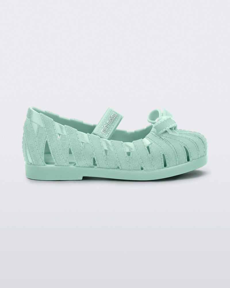 Side view of a glitter green M Lover Ballerina baby flat with bow and strap