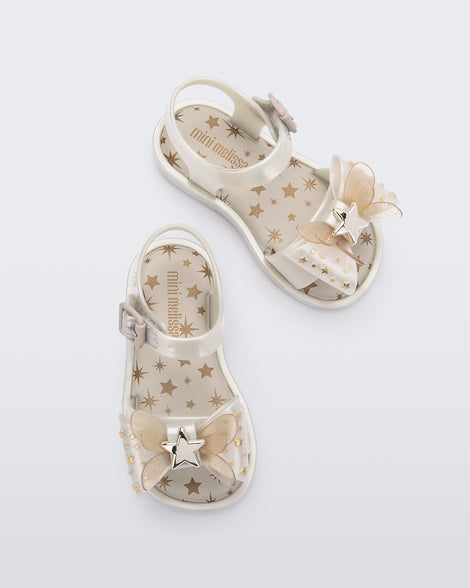 Overhead view of a pair of Mini Melissa Mar Sandals with star print for baby in white with butterfly bow applique and velcro closure on ankle strap.