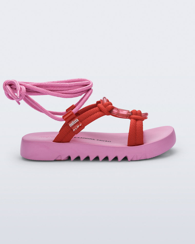Side view of an  pink sole, red upper, and pink ankle strap Kirk + Alexandre Pavao sandal