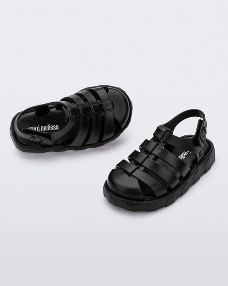 Angled view of a pair of black Megan baby sandals.