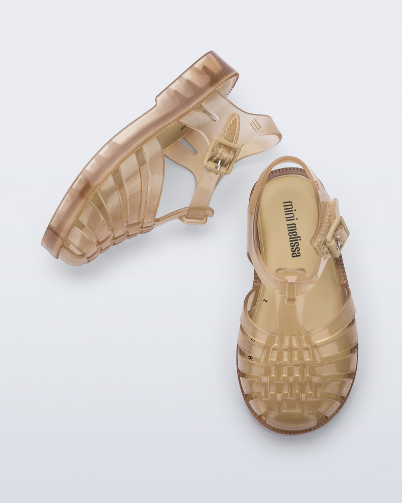 Side and top view of a pair of clear beige Possession baby sandals