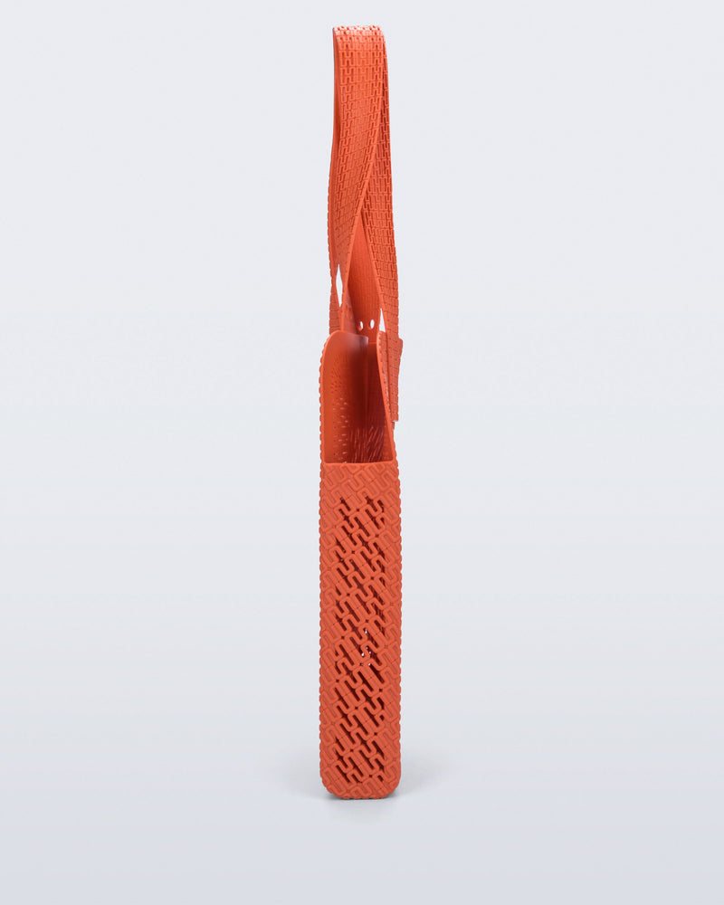Side view of an orange Harper bag with shoulder straps