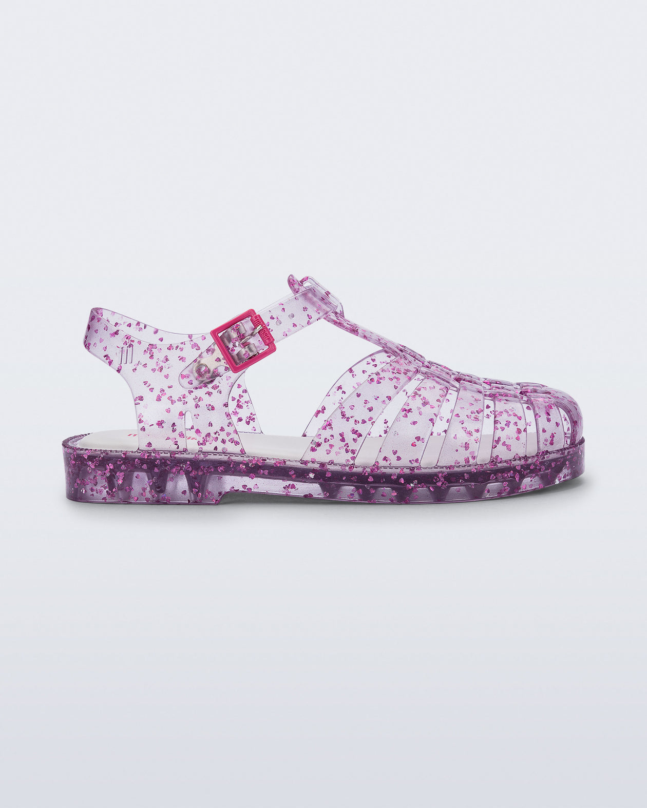Side view of a clear Possession kids sandal with pink heart glitter