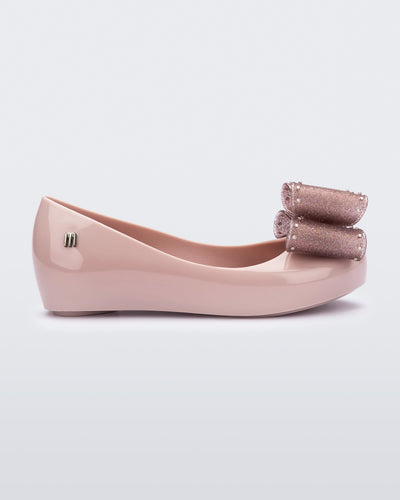 Side view of a light pink Ultragirl Classic Bow kids flat with glitter pink bow on top