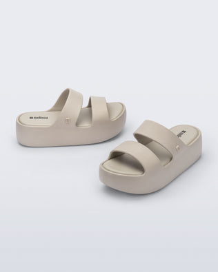 Angled and side view of a pair of beige Free Line Platform slides