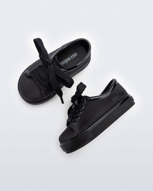 Side and top view of a pair of black baby Hip Sneakers