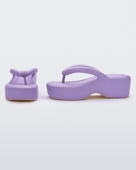 Front and side view of a pair of Melissa Free platform flip flops in lilac with tan soles