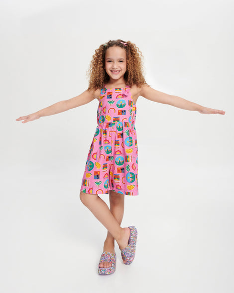 Child model in a pink patterned dress wearing a pair of lilac Free Platform slides + Hello Kitty and Friends kids sandals with Hello Kitty and Friends print