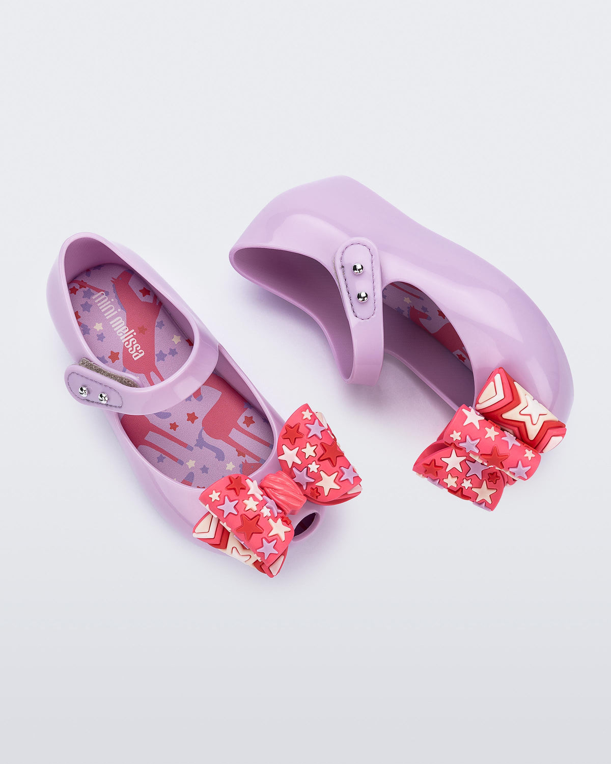 Top and side view of a pair of lilac with pink star patterned bow Ultragirl Wonderland baby flats