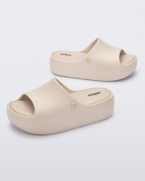 Angled view of a pair of beige Free Platform women's slides