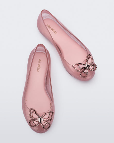 Top view of a pair of glitter pink Mini Melissa Sweet Love Butterfly flats with a pink butterfly detail on the toe