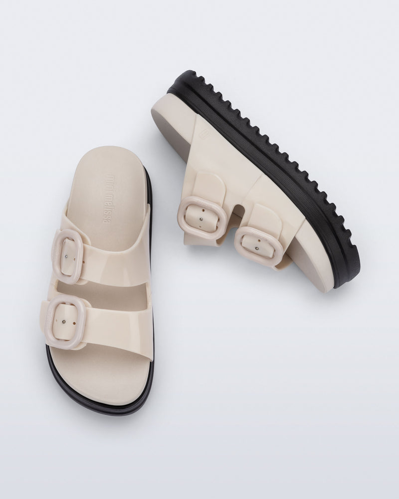 Side and top view of a pair of beige Cozy Platform kids slides with two straps with buckles and black sole