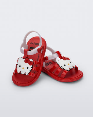 Angled view of a pair of red Hip + Hello Kitty and Friends sandals with white ankle straps and Hello Kitty on upper