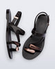 Top  and side view of a pair of black Iris sandals with copper upper embellishments