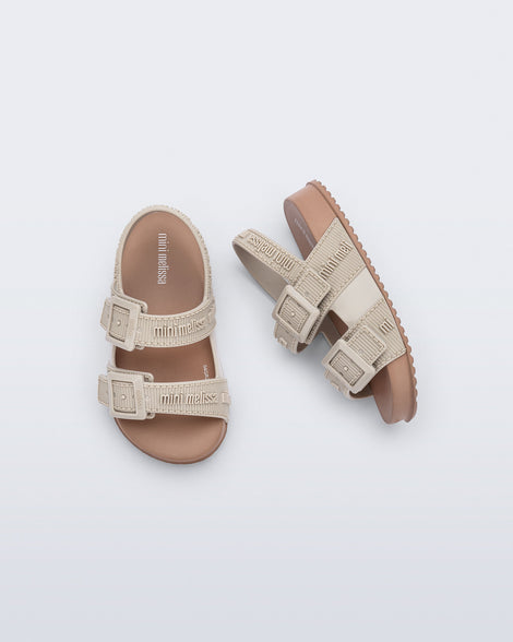 Top and side view of a pair of beige Cozy M Lover baby sandals