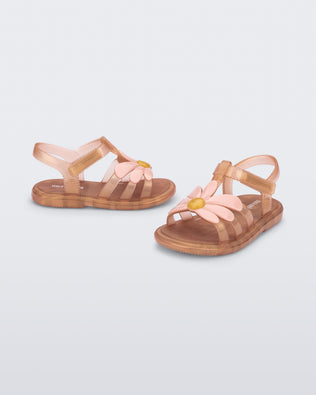 Angled view of a pair of pearly brown baby Hip Bloomy sandal with pink flower