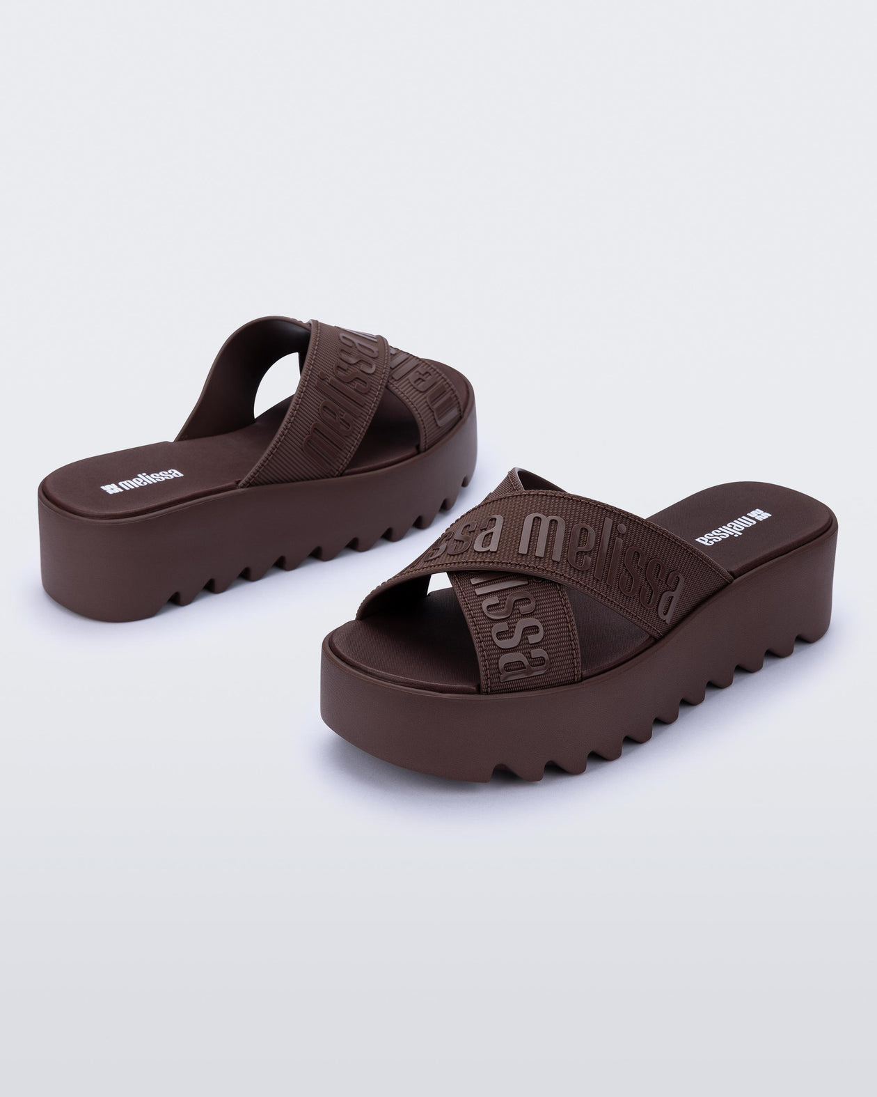 Back and side view of a pair of brown M Lover Cross Strap platform slides