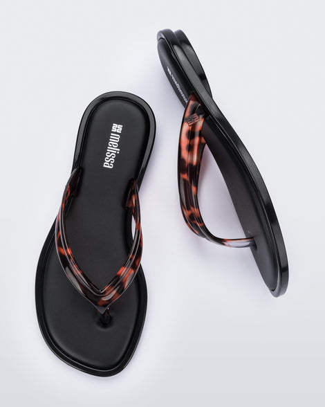 Side and top view of a pair of tortoise Wave Flip Flops with small heel and black sole