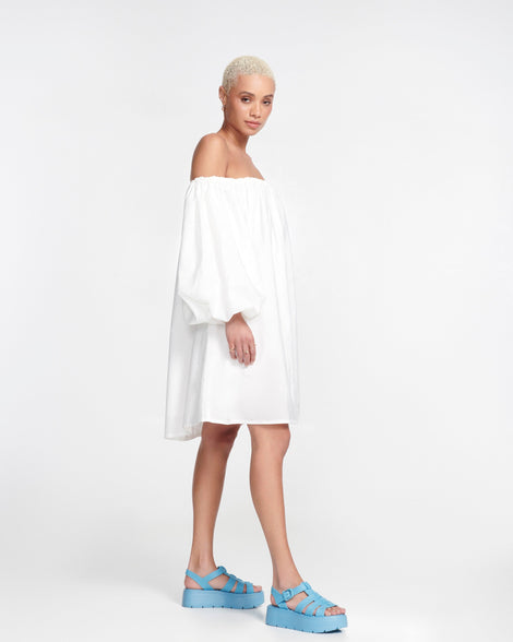 Model in a white dress wearing a pair of blue Up Platform sandals