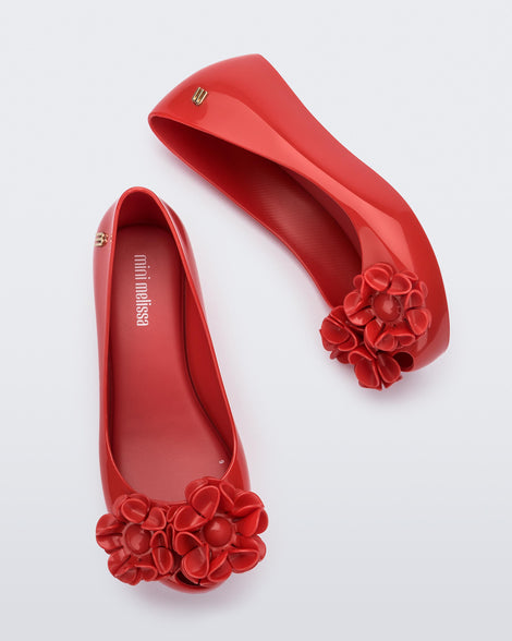 Side and top view of a pair of a red Ultragirl Springtime kids flat with two red flowers and peep toe.