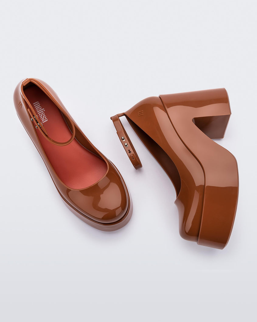 Top and side view of a pair of brown Melissa Doll Heel platforms with ankle strap and red insole.