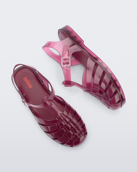 Side and top view of a pair of clear cranberry Possession fisherman sandals