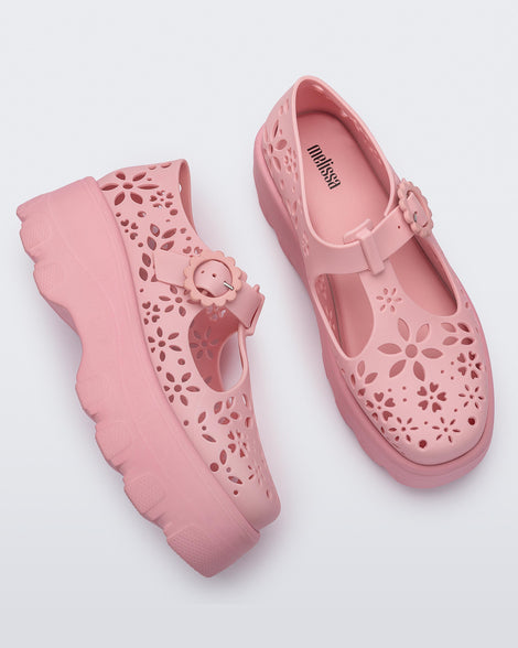 Side and top view of a pair of pink Kick Off Lace women's platform shoe with buckle.