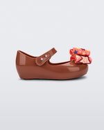 Side view of a brown with orange patterned bow Ultragirl Wonderland baby flat