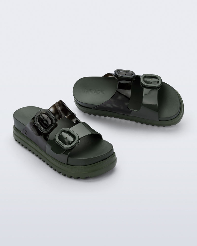 Angled view of a pair of dark green Cozy Platform slides with two straps with buckles