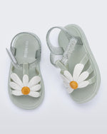 Top view of a pair of metallic green Hip Bloomy baby sandals with white daisy on top