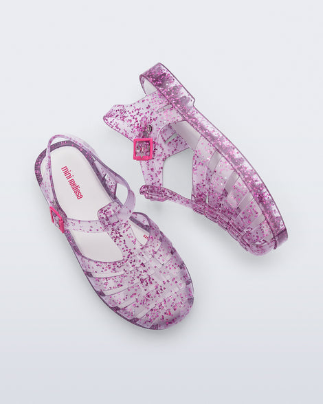 Side and top view of a pair of clear Possession kids sandals with pink heart glitter