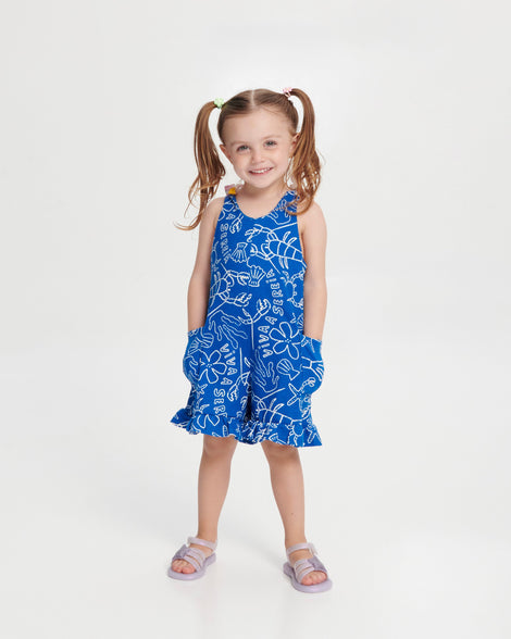 Child model in a blue dress wearing a pair of pearly purple Hip Sky baby sandals with a glitter purple star on top